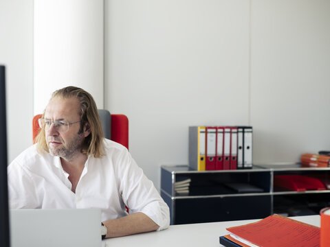 Philipp Grabensee sitzt an einem Schreibtisch