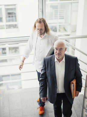 Herr Waider und Herr Grabensee gehen durch ein Treppenhaus